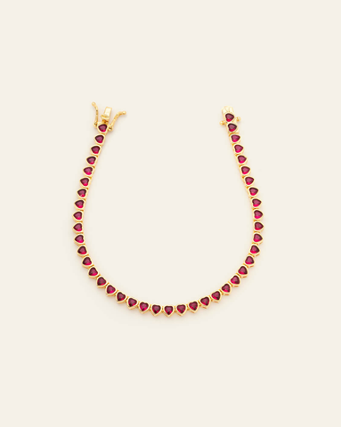 hero image of 14k gold vermeil 3mm ruby CZ heart tennis bracelet on cream background.