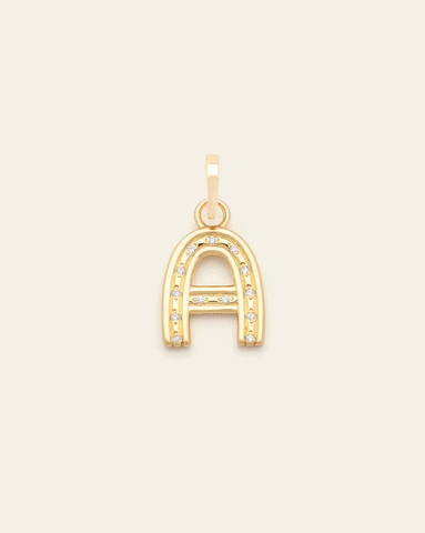 Animated image of a gold vermeil letter charms flashing through alphabet charms embellished with small sparkling stones along the front, displayed against a light beige background.