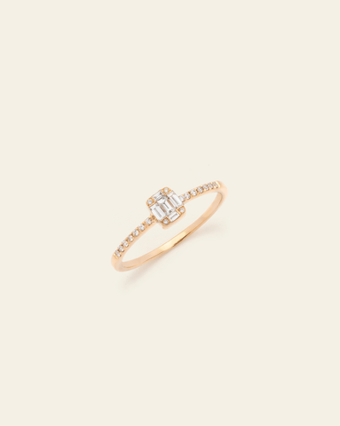 A 14k Yellow Gold ring featuring a mosaic of baguette-cut diamonds and a row of smaller round diamonds along the band on a cream background. 