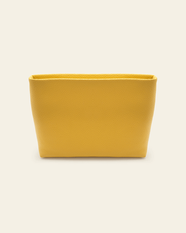 hero image on essentials pouch in golden pebbled leather on cream background.