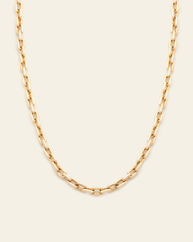 A photo of a Gold Vermeil chain with interlocking links displayed against a cream background.