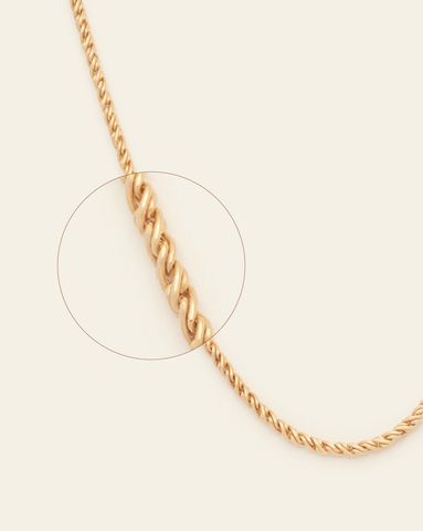 A magnified image of Gold Vermeil thick rope chain with a luxe twisted, textured design featuring on a cream background.