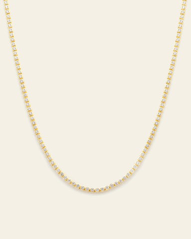 A Gold Vermeil petite bezel set tennis necklace with CZ stones displayed on a cream background.