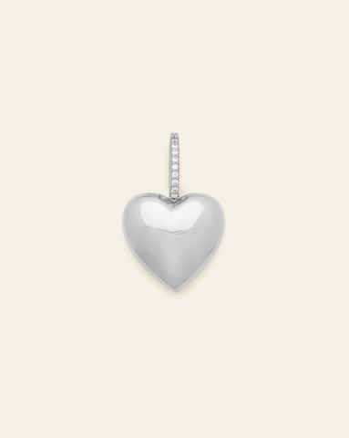 hero image of sterling silver puffed heart pendant with CZ stones on cream background.