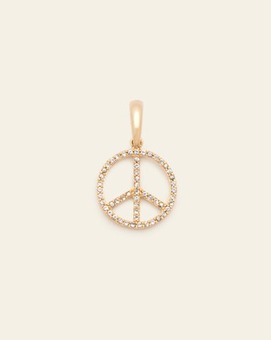 Gold pendant featuring a diamond-studded peace sign against a light beige background.