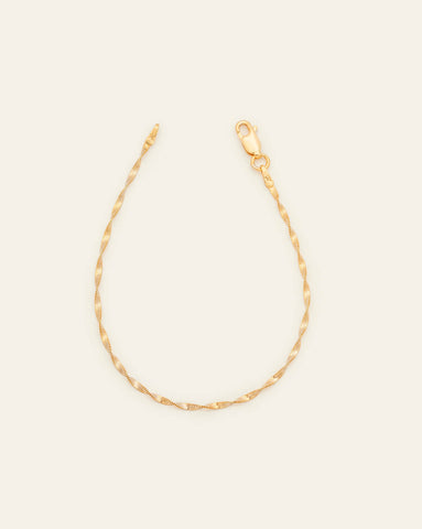 A Gold Vermeil Singapore bracelet with a twisted, textured design featuring a lobster clasp on a cream background.