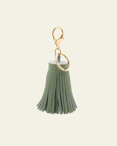 hero image of tassel key chain in pistachio pebbled leather on cream background.