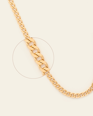 A magnified close up solid gold thick curb chain.