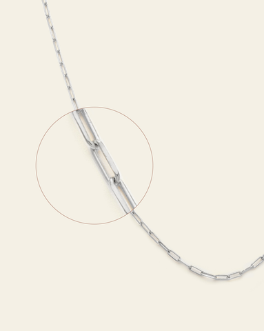 A magnified close up of sterling silver thin staple chain.